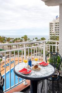 a table with food and drinks on a balcony overlooking the ocean at Juanvi's Corner in Costa de Adeje