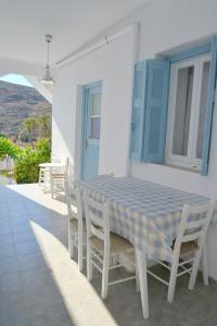 una mesa y sillas azules y blancas en un patio en Filippos en Adamas