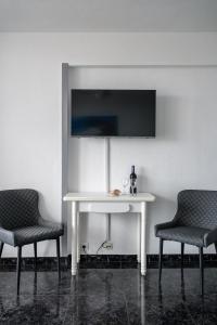 a white table with two chairs and a tv on a wall at Juanvi's Corner in Costa de Adeje