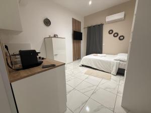 a white room with a bed and a room with a television at Bonpas Appart Hotels in Avignon