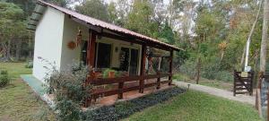 a small house with a porch and a fence at "La morenita", acogedora cabaña para dos in Santa Ana