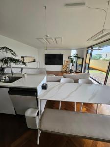 a kitchen and living room with a sink and a table at Wind Flower in Seogwipo