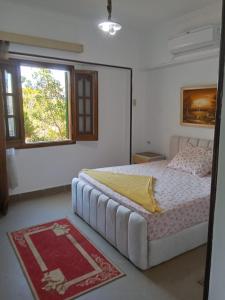 ein Schlafzimmer mit einem großen Bett mit Fenster in der Unterkunft chalet 1 villa150 4 bedrooms ground floor green beach in El-Alamein