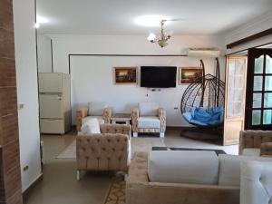 ein Wohnzimmer mit Sofas und einem Flachbildfernseher in der Unterkunft chalet 1 villa150 4 bedrooms ground floor green beach in El-Alamein