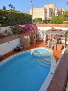 ein großer Pool in der Mitte eines Gartens in der Unterkunft chalet 1 villa150 4 bedrooms ground floor green beach in El-Alamein