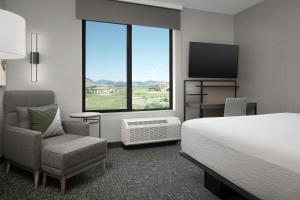a hotel room with a bed and a chair and a television at TownePlace Suites by Marriott Bozeman West in Bozeman