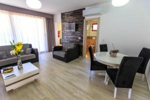 a living room with a couch and a table with chairs at Apartments Matkovic Lux in Sutomore