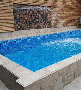 a swimming pool with blue water in a building at Casa para família com piscina in Guarujá