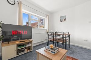 a living room with a tv and a dining table at Flat with free parking in Oxford in Oxford