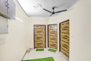 a room with wooden doors and green carpet at Super Hotel O Shankar Hotel Ghaziabad Railway Station in Ghaziabad