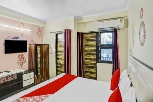 a bedroom with a bed and a tv and a window at Super Hotel O Shankar Hotel Ghaziabad Railway Station in Ghaziabad