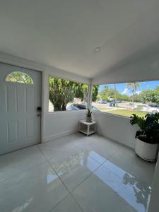 Habitación blanca con puerta y ventana en North Miami Vacation Home, en North Miami Beach 1 foto más