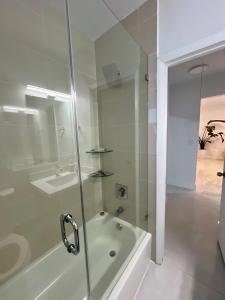 Un baño con ducha, bañera y lavabo. en North Miami Vacation Home, en North Miami Beach