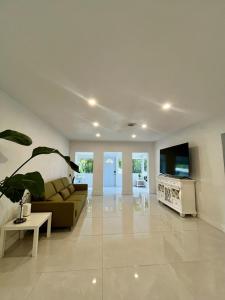 Una sala de estar con un sofá y un televisor. en North Miami Vacation Home, en North Miami Beach