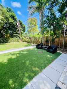 Un patio con dos sillas negras en el césped. en North Miami Vacation Home, en North Miami Beach