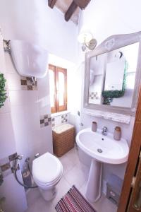 a bathroom with a sink and a toilet and a mirror at Casa Graziella Piccolo Pied à terre nel Castello di Palazzo d'Assisi in Palazzo