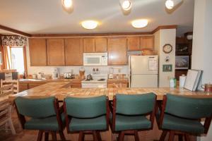 eine Küche mit einem großen Holztisch und grünen Stühlen in der Unterkunft Mountainback #34, Corner in Mammoth Lakes