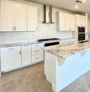 a kitchen with white cabinets and a marble counter top at Cozy Private master bedroom in a single family house in Elk Grove