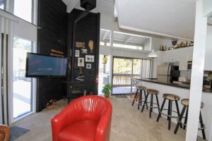 a living room with a red chair and a kitchen at Sierra Park Villas #89 in Mammoth Lakes +7 photos