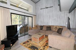 Una sala de estar con un sofá y un televisor. en Sierra Park Villas #93, en Mammoth Lakes