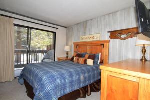 Un dormitorio con una cama y una ventana grande. en Sierra Park Villas #93, en Mammoth Lakes