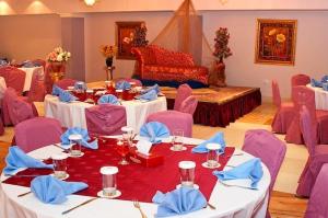 Habitación con mesas, sillas moradas y cama en Safeer Plaza Hotel, en Mascate