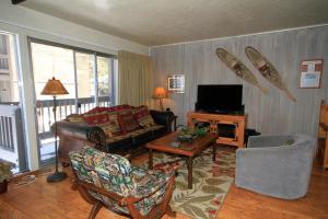 Una sala de estar con un sofá y un televisor. en Sierra Park Villas #16, en Mammoth Lakes