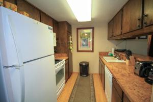 a kitchen with a white refrigerator and wooden cabinets at Discovery 4 137 in Mammoth Lakes