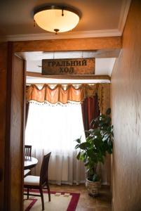 a hallway with a table and a window with a sign at Hotel-Restaurant Lyube Plus in Khmelnytskyi
