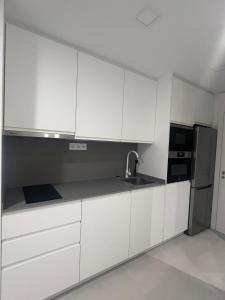a kitchen with white cabinets and a stainless steel refrigerator at Alondras Luxury Paradise fully renovated in Arona