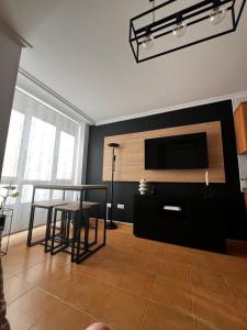 Una sala de estar con un televisor de pantalla plana y una mesa. en MANSIÓN DEL INDIANO, en Viveiro