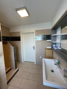 a bathroom with a white tub and a sink at Ferienwohnung Sonnendeck einladend und freundlich in Laupheim