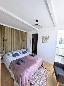 a bedroom with a large bed with a purple blanket at Gite Bernard Lafon in Castillon-la-Bataille
