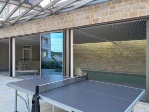 una mesa de ping pong frente a una pared de ladrillo en Le castel T2 piscine et vue mer plage, en Bonne Nouvelle 23 fotos más