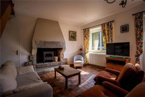 un salon avec un canapé et une cheminée dans l'établissement Ty Moune proche mer, à Penvénan