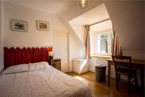 une chambre avec un lit, un bureau et une fenêtre dans l'établissement Ty Moune proche mer, à Penvénan