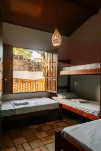 a room with three bunk beds and a window at Chalé Da Lú 2Room Balcony OutdoorBBQ Private Garage in Pipa