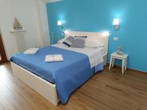 a bedroom with a large bed with a blue wall at Zagare & Trabocchi - Dimora di mare in Rocca San Giovanni +44 photos
