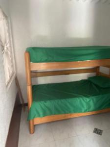 a small green bed in a corner of a room at Casa En Flandes ARAGON 1 in Flandes