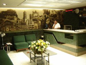 a man sitting at a desk in a waiting room at Hotel San Miguel in Puebla