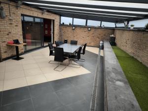 a patio with a table and chairs in a building at Villa 8 chambres pour 20 personnes in Charleroi
