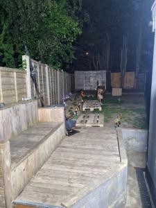 a backyard with a fence and a wooden deck at New double room on gf in London