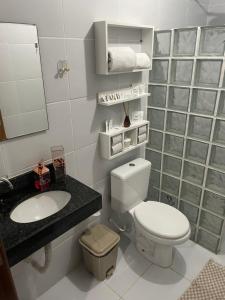 a bathroom with a toilet and a sink and a mirror at Flat Luxxor 50 metros da praia Jacumã in Conde
