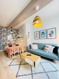 a living room with a blue couch and a bed at Provins au coeur du quartier historique - Charmant studio pour 2 in Provins