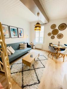 a living room with a blue couch and a table at Provins au coeur du quartier historique - Charmant studio pour 2 in Provins +10 photos