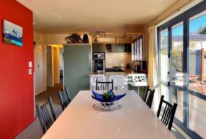 a kitchen and dining room with a table and chairs at Pukeko Palace - Lake Tekapo in Lake Tekapo