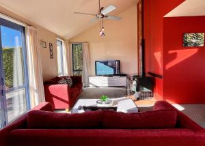 a living room with a couch and a tv at Pukeko Palace - Lake Tekapo in Lake Tekapo
