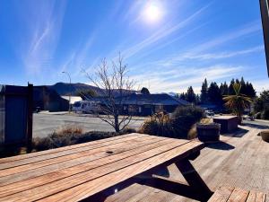 a wooden bench sitting on top of a deck at Pukeko Palace - Lake Tekapo in Lake Tekapo