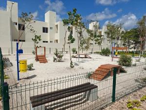 a playground behind a fence in front of a building at Casa Maya comfortable apartment in Tulum in Tulum