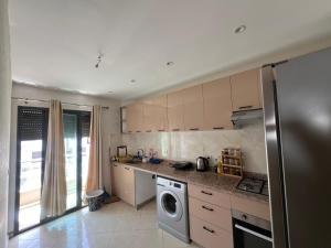 a kitchen with a refrigerator and a washer and dryer at Florida Waves in El Jadida
